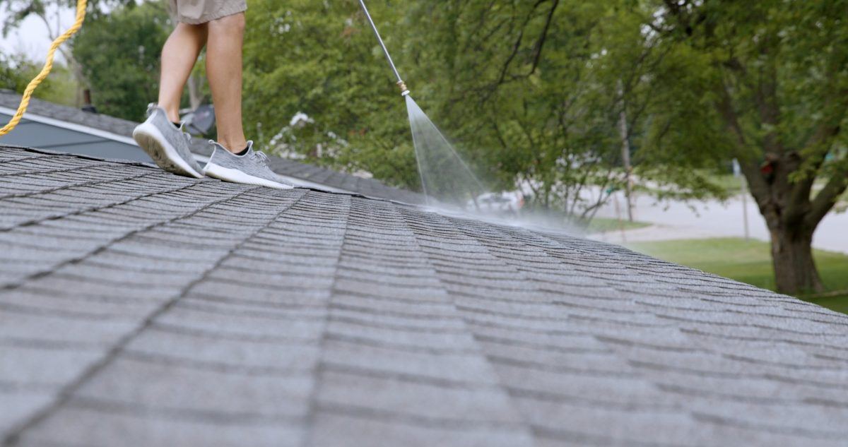 Fresh Roof treatment being sprayed across an asphalt shingle roof